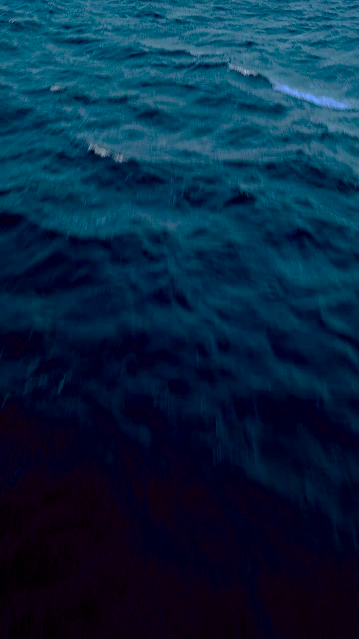 Vertical HD drone view of textured ocean waves from above with steady forward motion over deep blue Caribbean sea