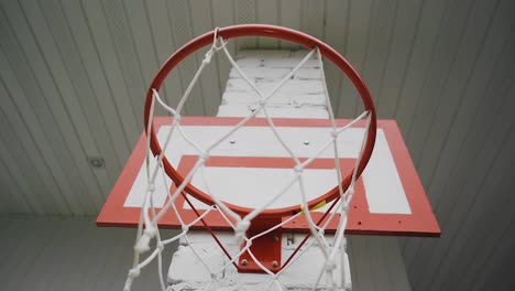 a basketball net hangs on the wall in the courtyard of a private house.