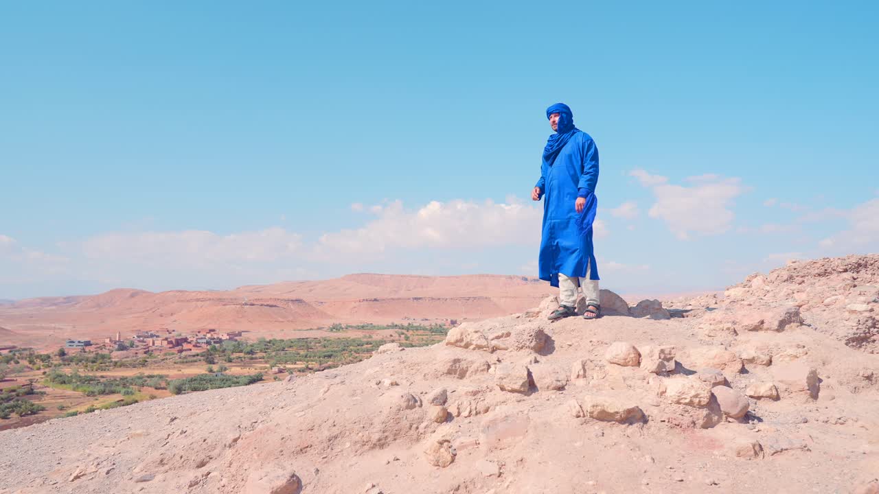 모로코 사막 풍경에서 파란색 전통 옷을 입은 남자