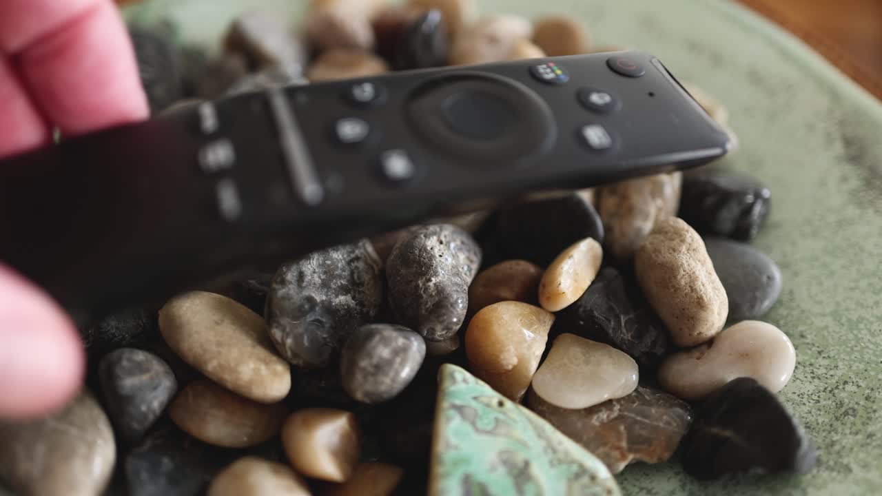 손은 바위 바닥에 리모컨을 놓습니다.