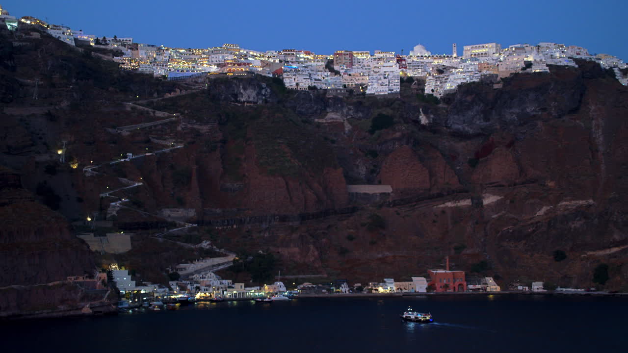 pintorescos edificios blancos en lo alto de un acantilado de thera, santorini, grecia con camino de burro