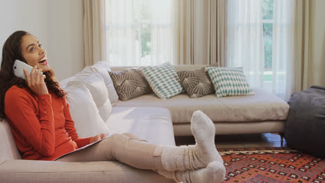 happy woman sitting on sofa with documents in her hand talking on phone 4k 4k