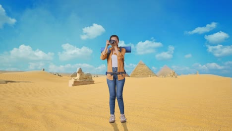woman photographing pyramids in the egyptian desert