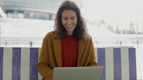 Glückliche-Junge-Frau,-Die-Im-Freien-Einen-Laptop-Benutzt