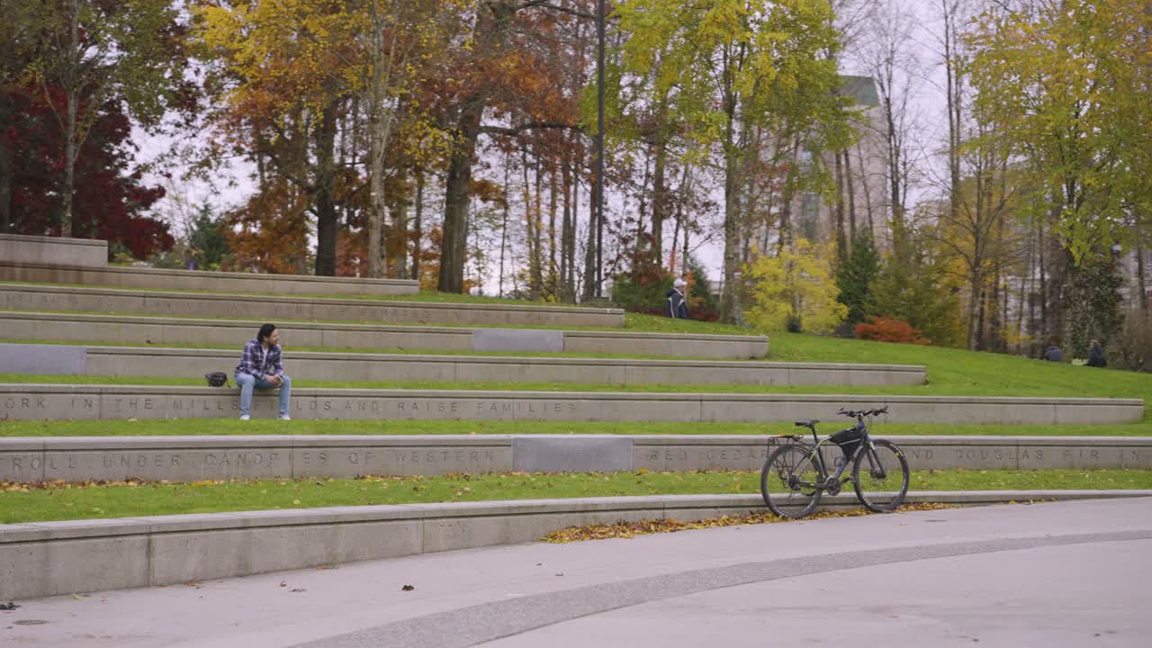 a man with a bicycle resting near lake lafarge.