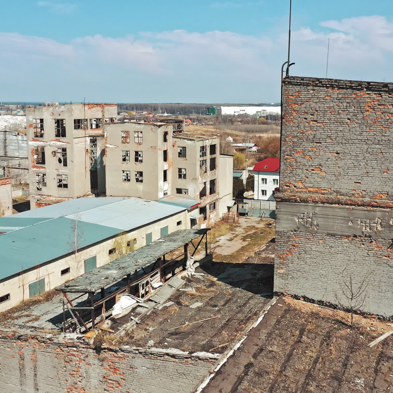 Flying over the desolate place with many abandoned buildings in a city after the military actions. Ruined city with empty buildings outdoors. Aerial view