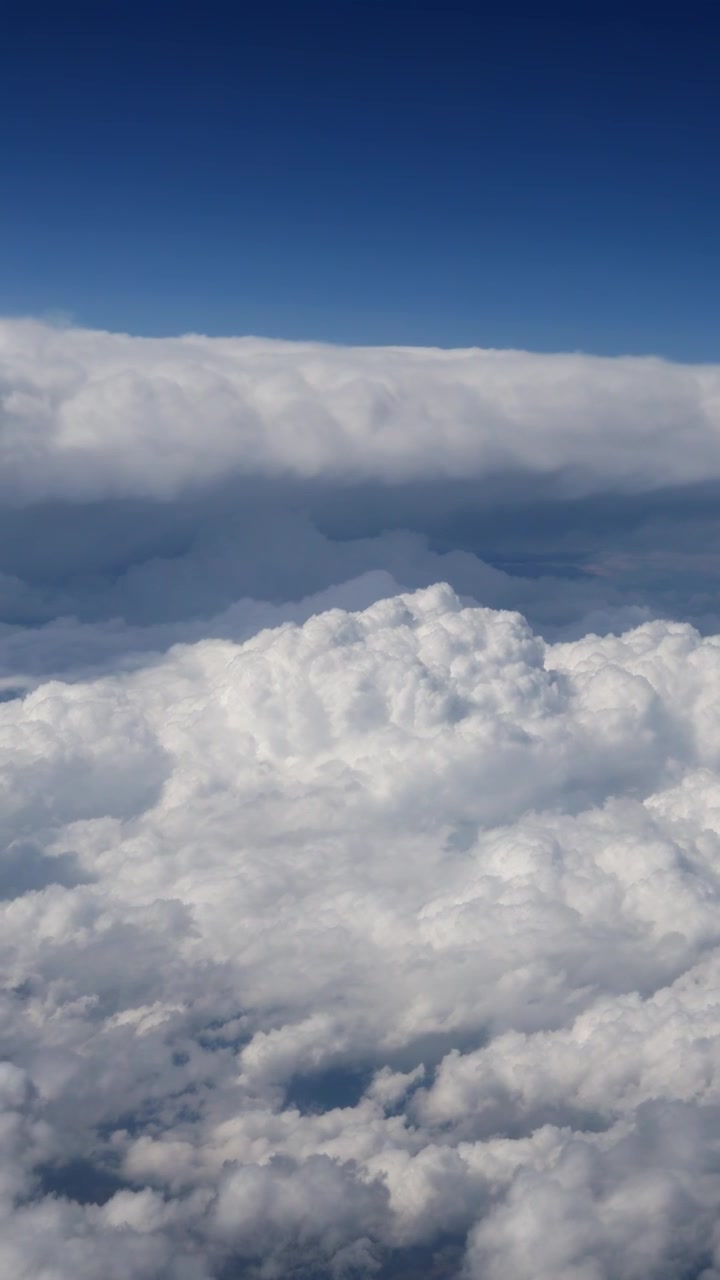 Dramatic white cloudscape above the sky in vertical aerial view.