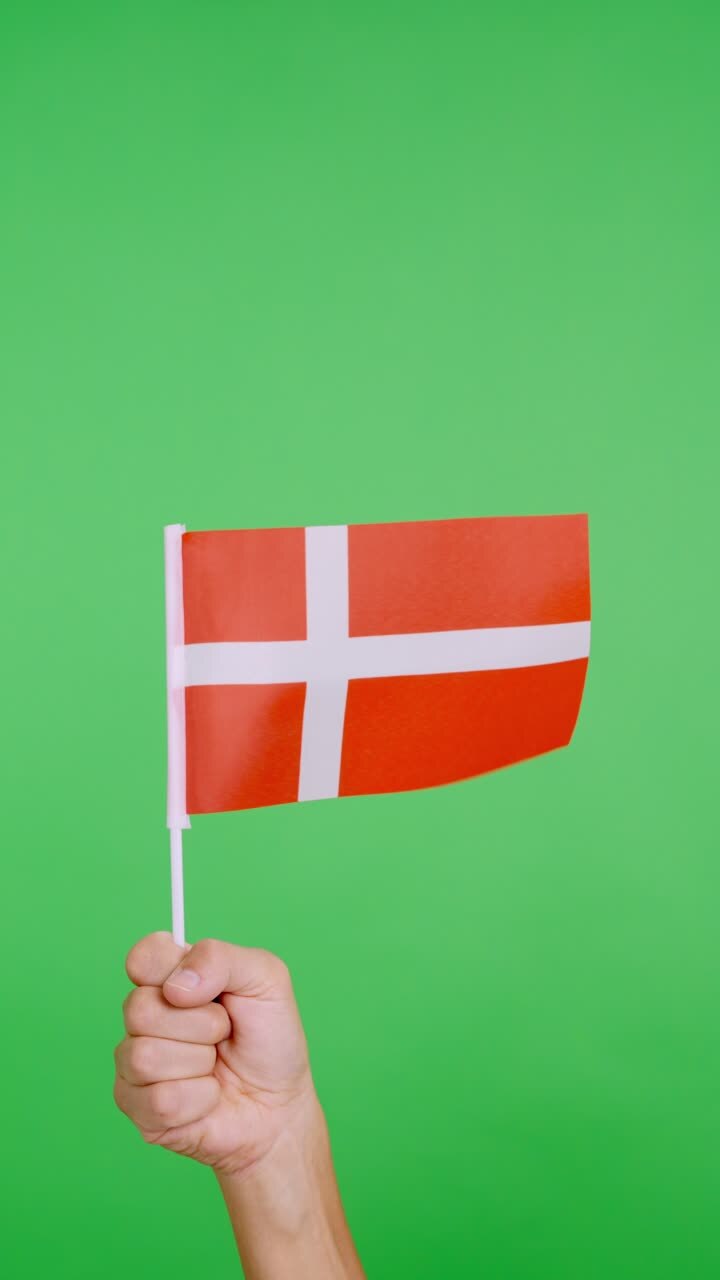 Hand lifting a danish pennant while waving by the wind