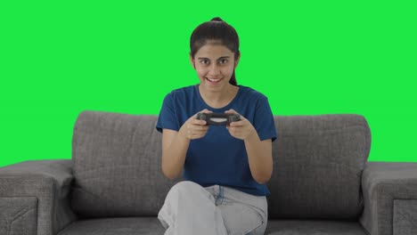 chica adolescente india feliz jugando videojuegos pantalla verde