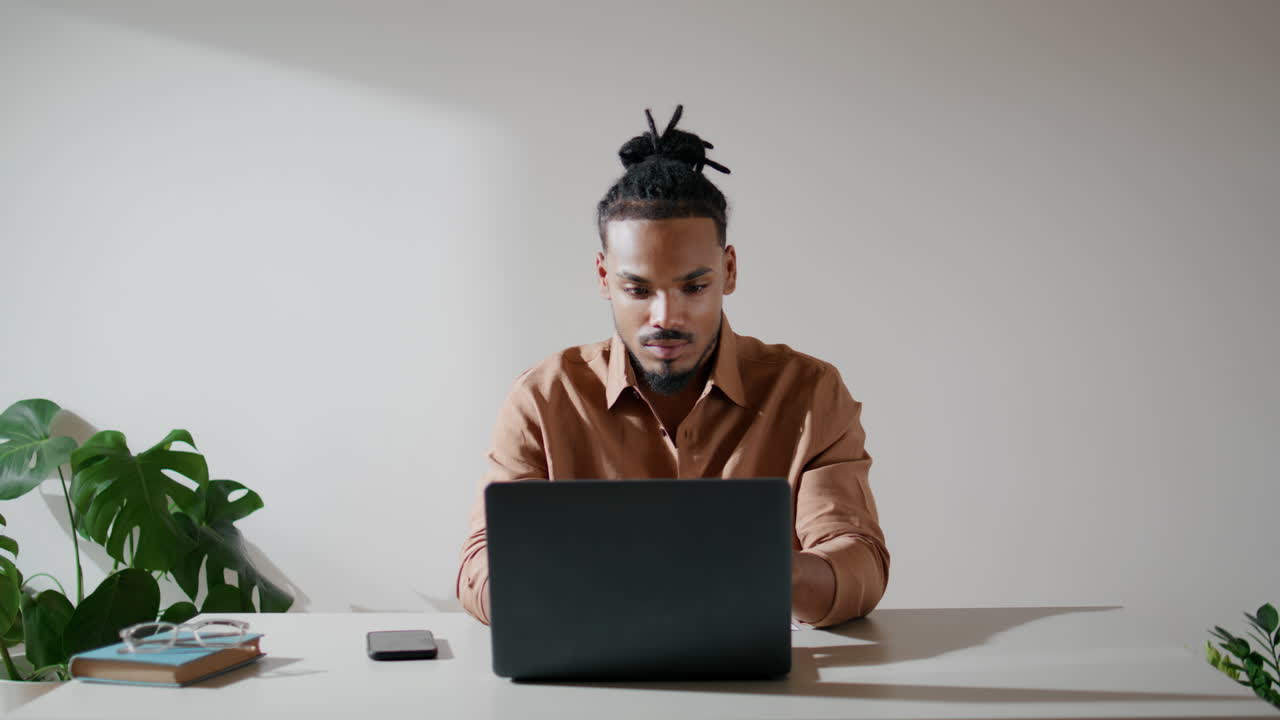 estudiante moderno escribiendo en el teclado en el lugar de trabajo. hombre enfocado viendo la pantalla en casa