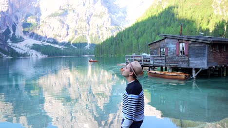 tourist man wear hat looking around fascinated by lago di braies, south tyrol