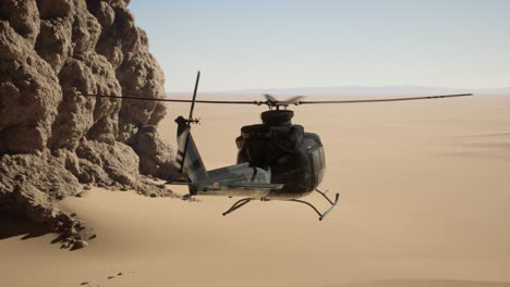 black helicopter flying over desert landscape