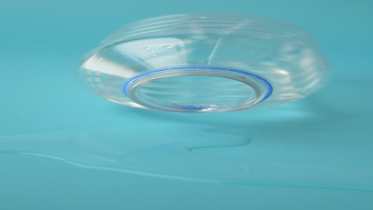 물 병이 파란색 표면에 흘러내립니다.