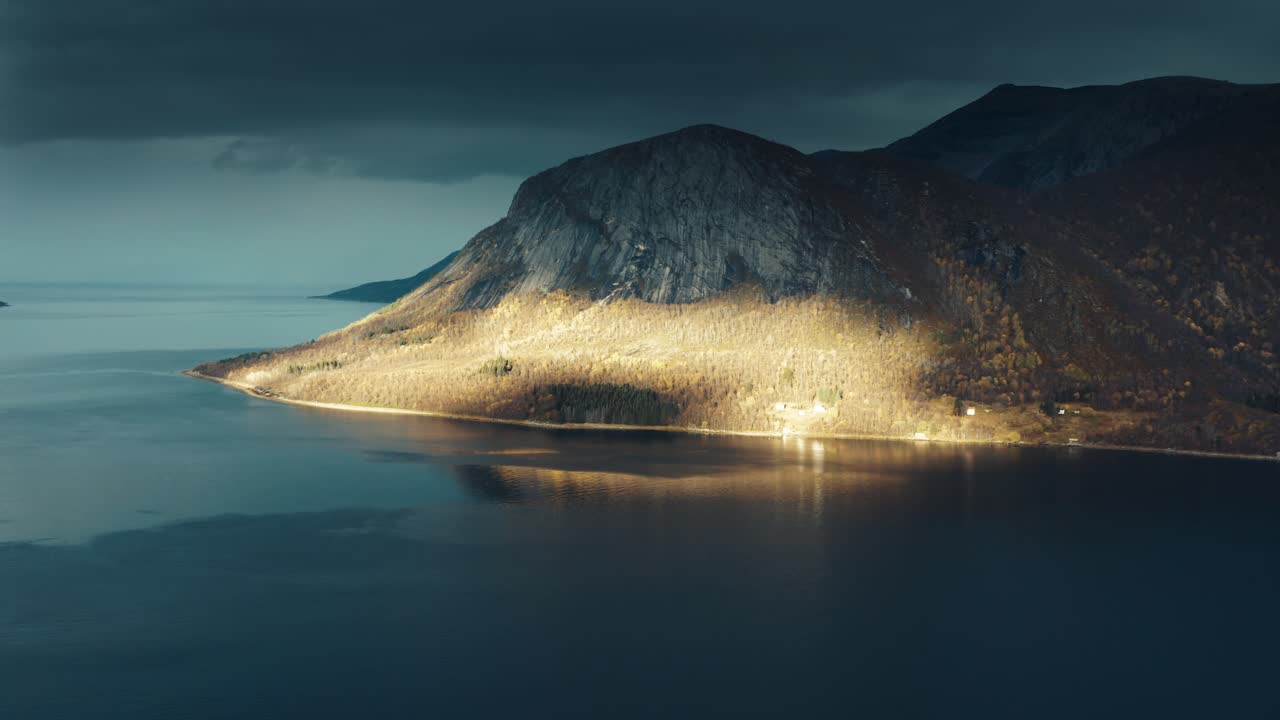 las nubes que pasan arrojan sombras oscuras sobre el fiordo y las montañas