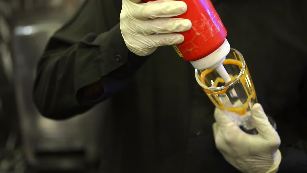 요리사 는 디저트 를 준비 하기 위해 유리 안 에 크림 을 적용 하고 있다