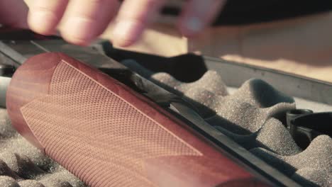 male loading a shell into a shotgun