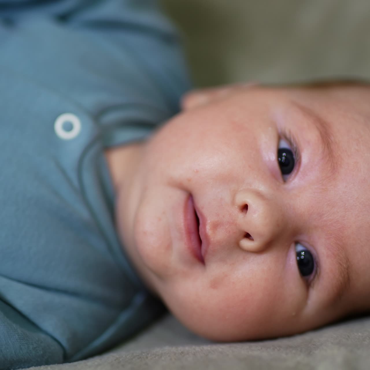 Lovely baby face lying on one check. Portrait of a child staring directly into camera. Close up