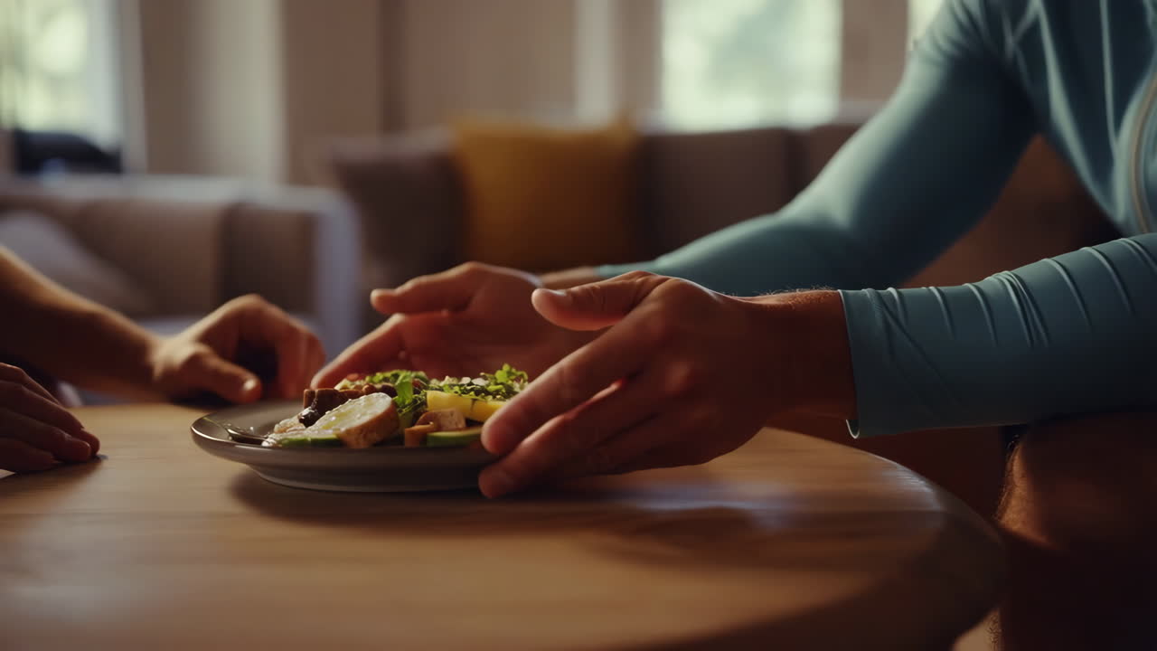 A person is holding a plate of food at a table
