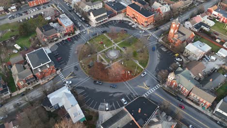 traffic on roundabout in small american city with playground park and american flag in center