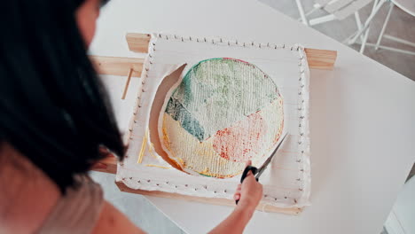 woman cutting a colorful fabric piece