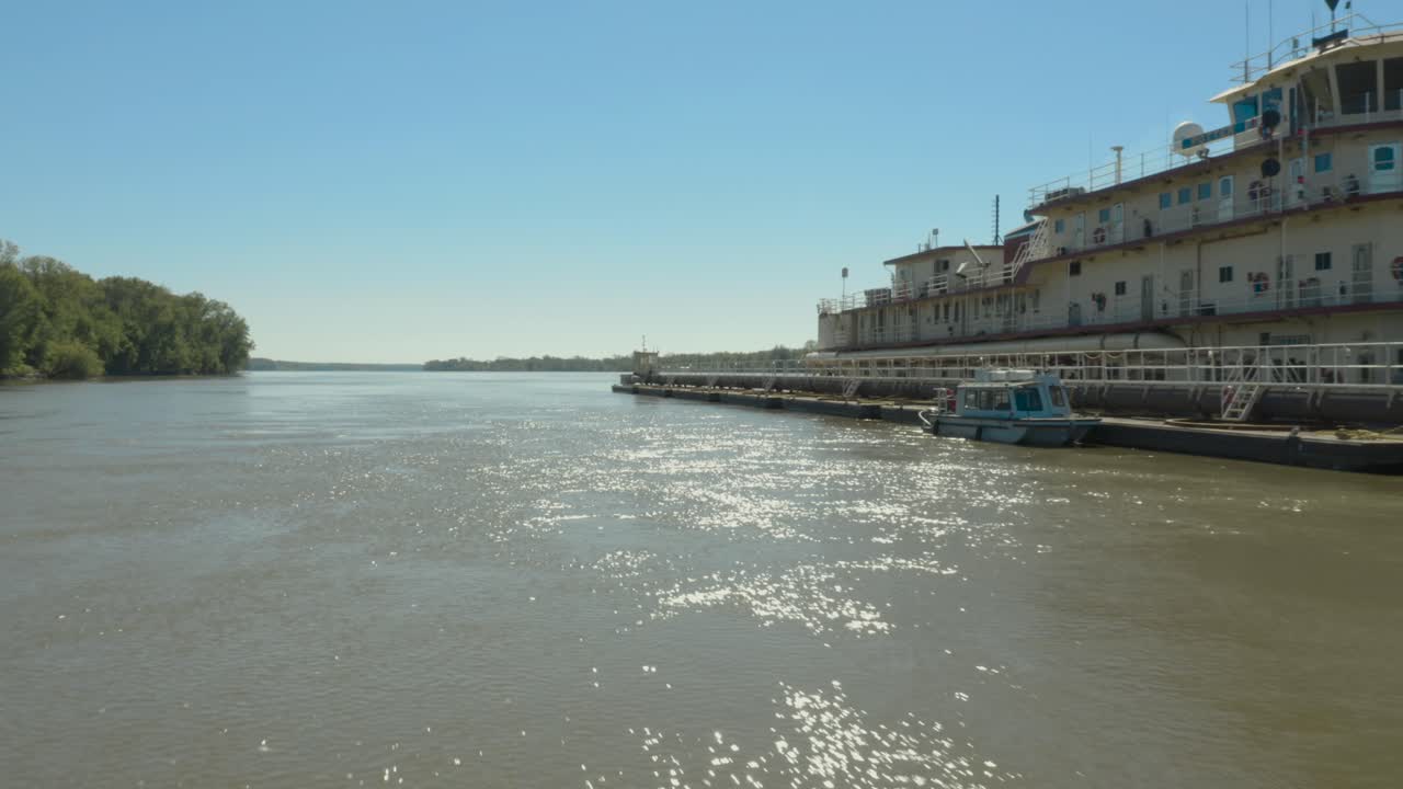 Low fly by of a barge on the Mississippi River during the summer. 4K footage