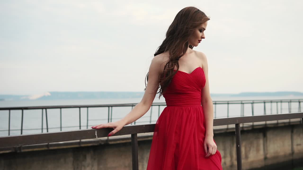 물가에서 빨간 드레스를 입은 여자