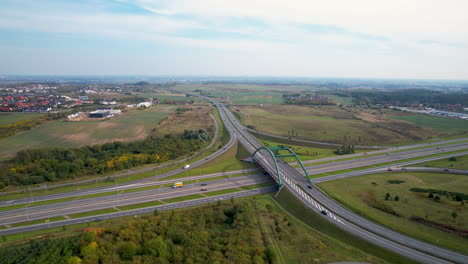 aerial rise up view of cars traffic on countryside highway interchange intersection in straszyn gdansk poland, nature suburban surroundings