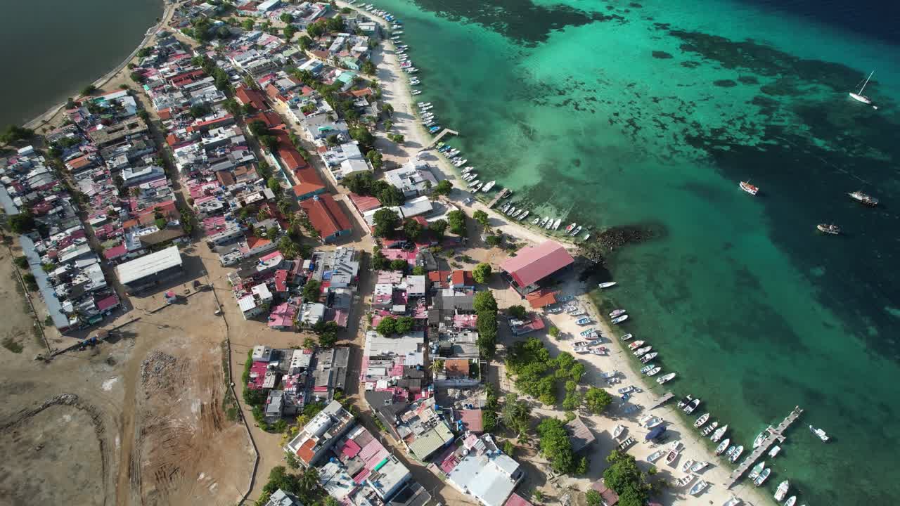 Gran roque, los roques, showing colorful town, turquoise waters, and a beachside pier, aerial view