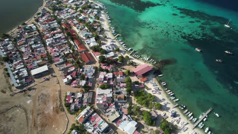 gran roque, los roques, showing colorful town, turquoise waters, and a beachside pier, aerial view