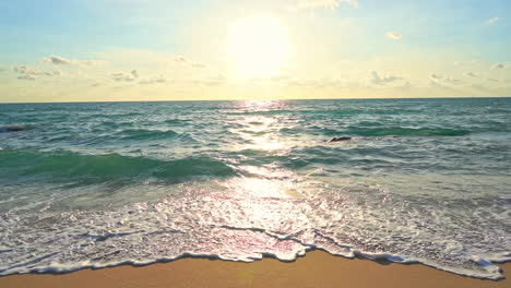 Cálido-Sol-Vespertino-Sobre-El-Agua-Del-Mar-Tropical-Y-Playa-De-Arena-Vacía,-Escena-Celestial-En-Un-Destino-Exótico