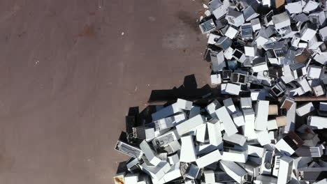 Top-down-aerial-view-of-discarded-white-household-appliances-at-rubbish-dump