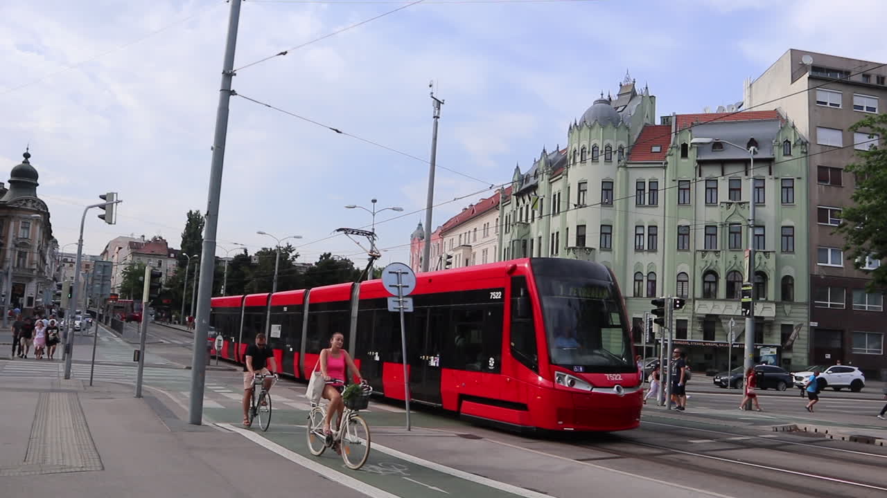 Red tram and cyclist in Bratislava city centre, Slovakia