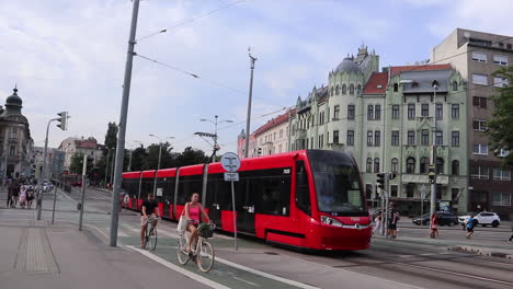 red tram and cyclist in bratislava city centre, slovakia