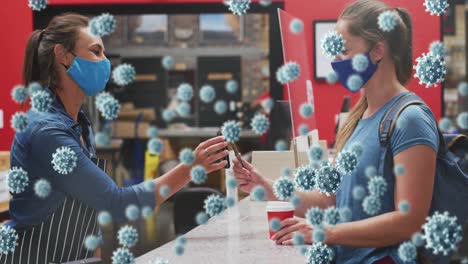 animation of virus cells over two caucasian women with face masks talking