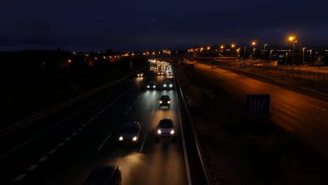 una toma desde un puente sobre la autopista del tráfico que ingresa a la ciudad antes del amanecer