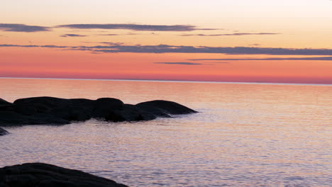 slow pan of cliffs, sea and horizon at colorful sunset in summer