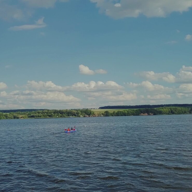 two men are rowing oars through the waves in the river in a kayak to the bank. Active weekend. Wonderful landscape