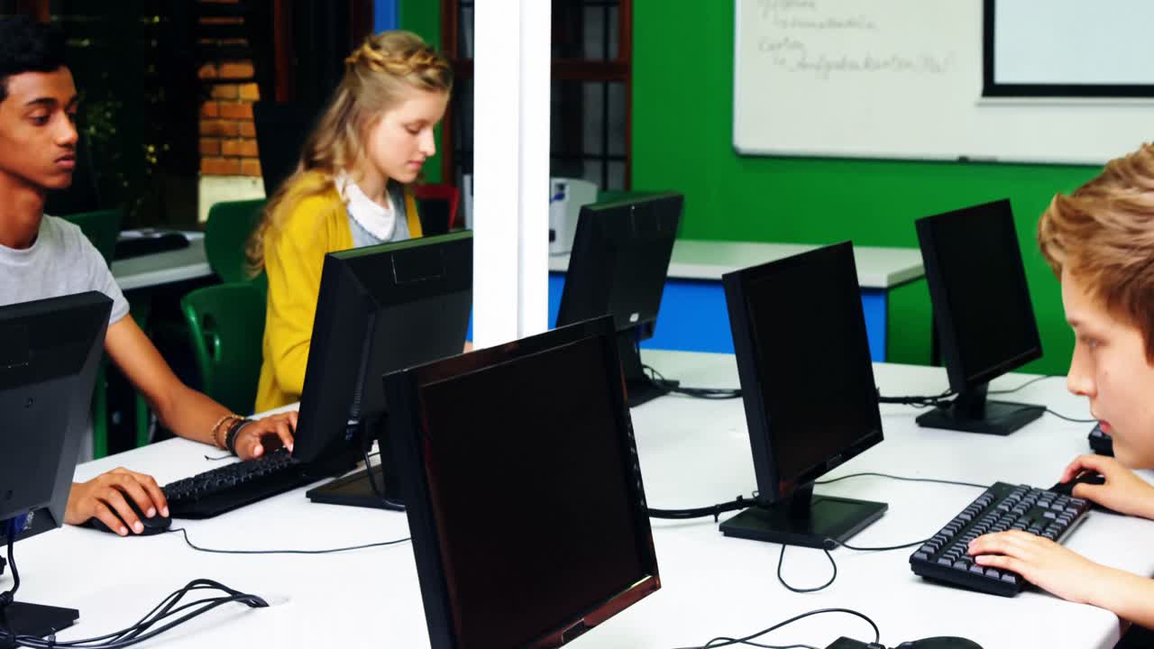 étudiants étudiant à l'ordinateur en classe