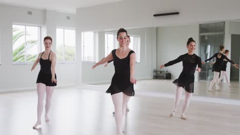 bailarinas caucásicas practicando una rutina de baile durante una clase de ballet