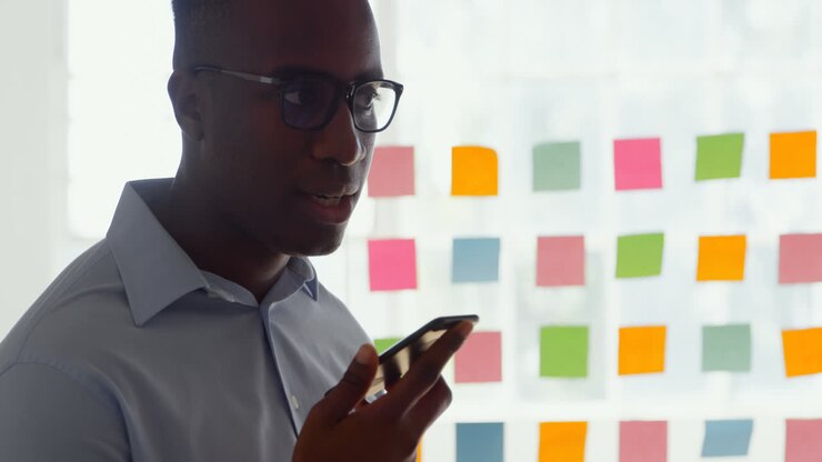 Side view of young black businessman talking on mobile phone in a modern office 4k