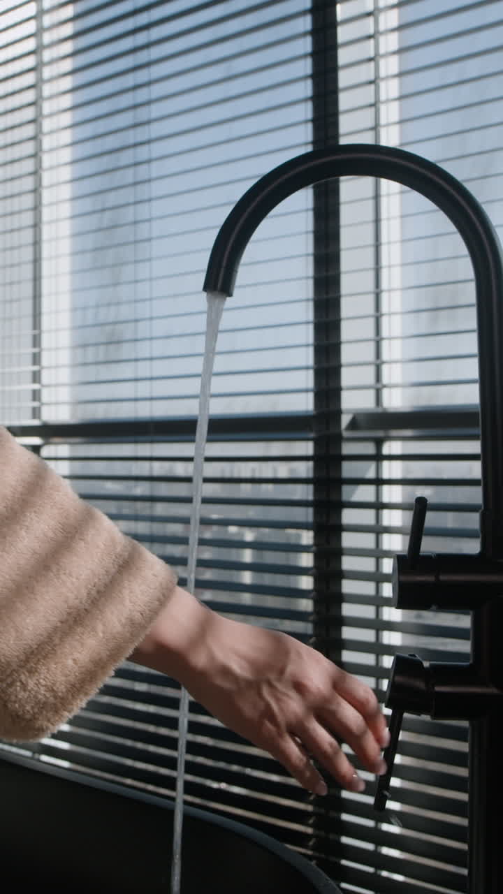 Washing Hands Under Modern Black Faucet