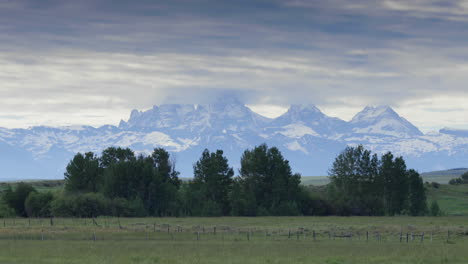 snowy grand teton mountains of wyoming seen from field in idaho, long shot