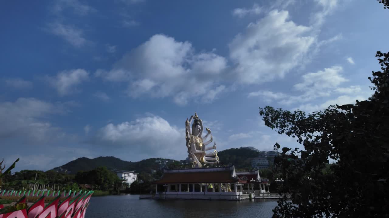 파란 하늘을 배경으로 태국 코사무이에서 물을 내려다보는 큰 황금 부처 동상