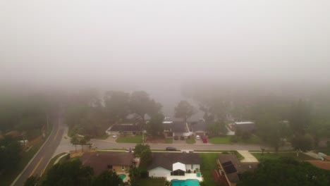 aerial flyover through foggy and misty neighborhood in city of ocoee, florida with no vehicles driving