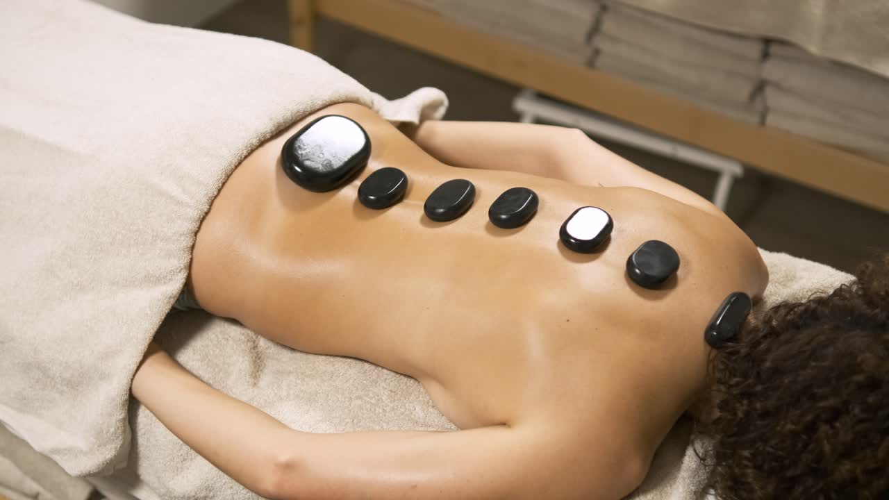Woman enjoying a relaxing hot stone back massage session