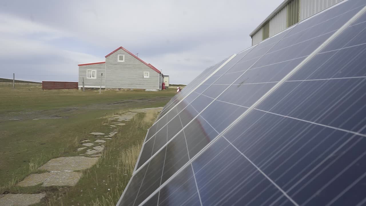 Solar panels standing next to isolated residential building, generating clean electricity using photovoltaic technology in rural landscape with sustainable energy production