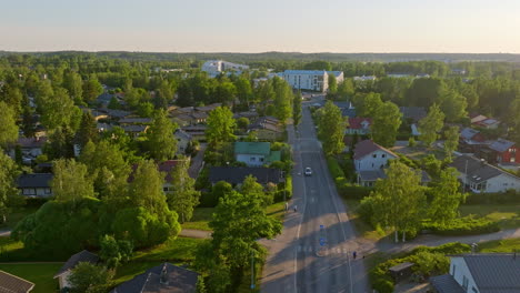 Drone-rising-along-a-quiet-street-in-the-suburbs-of-Helsinki,-summer-in-Finland