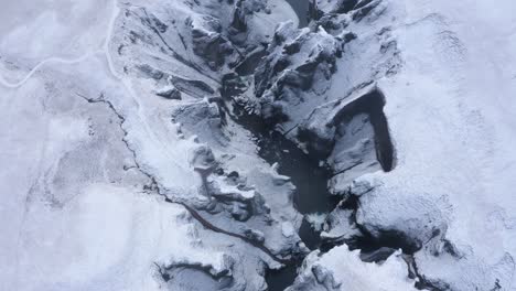 Fjaðrárgljúfur-Schlucht-In-Südisland-Im-Winter---Luftaufnahme-Von-Oben-Nach-Unten