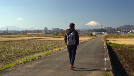 Tokio,-Japan---Ein-Männlicher-Tourist,-Der-Auf-Einer-Betonstraße-Zwischen-Den-Reisfeldern-Mit-Einer-Atemberaubenden-Schönheit-Des-Mt-Geht