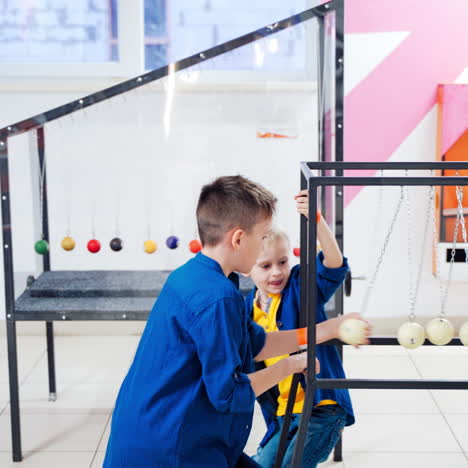 children at the science center experimenting with newton's cradle. the concept of physics. museum of science